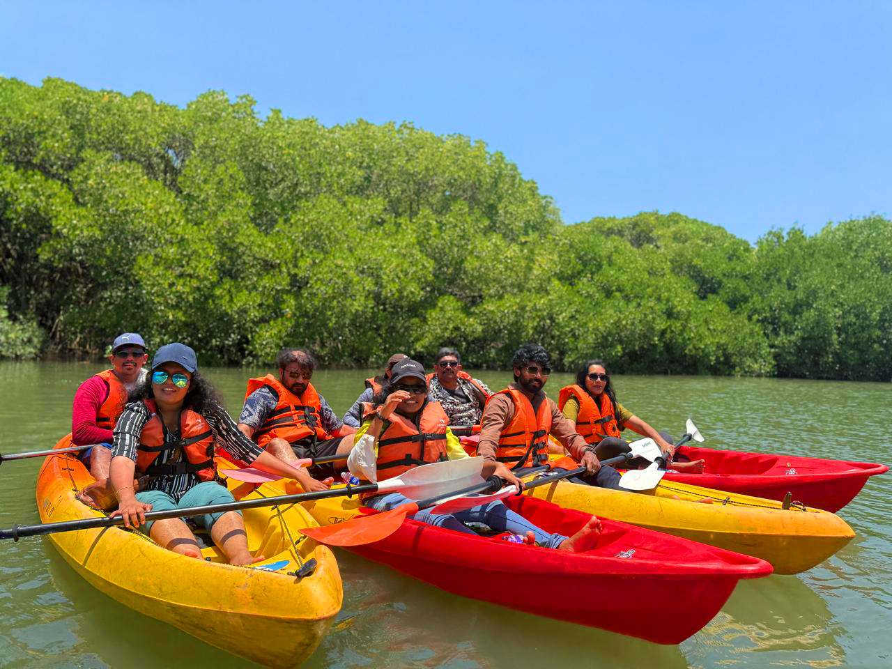 Kayak bow gliding through a still mangrove-lined backwater channel